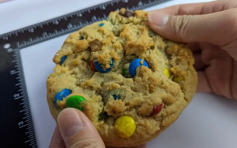 Crumbl cookies original with m&ms holding in hand - banhmifresh.com